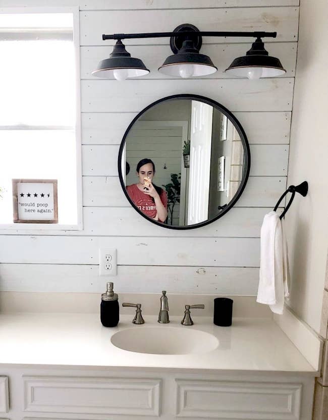 Reviewer's lighting is hung above a mirror in the bathroom