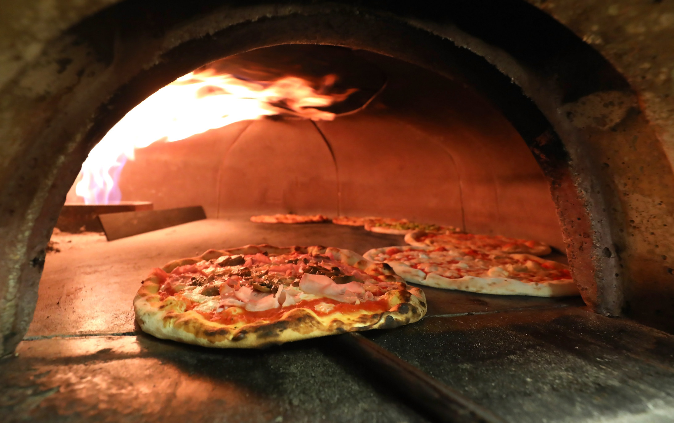 Pizzas in a fire-burning oven.