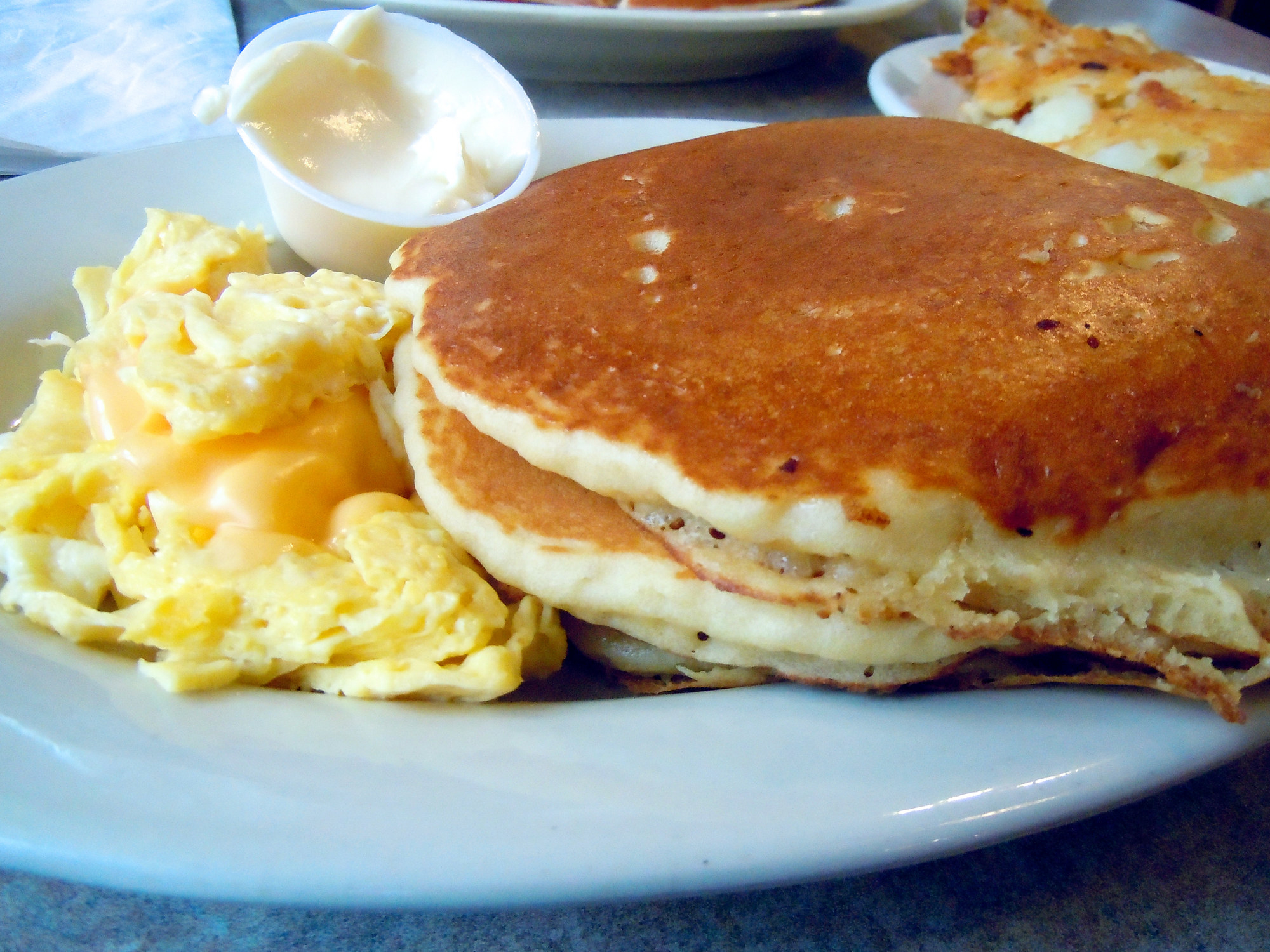 A stack of pancakes with eggs.