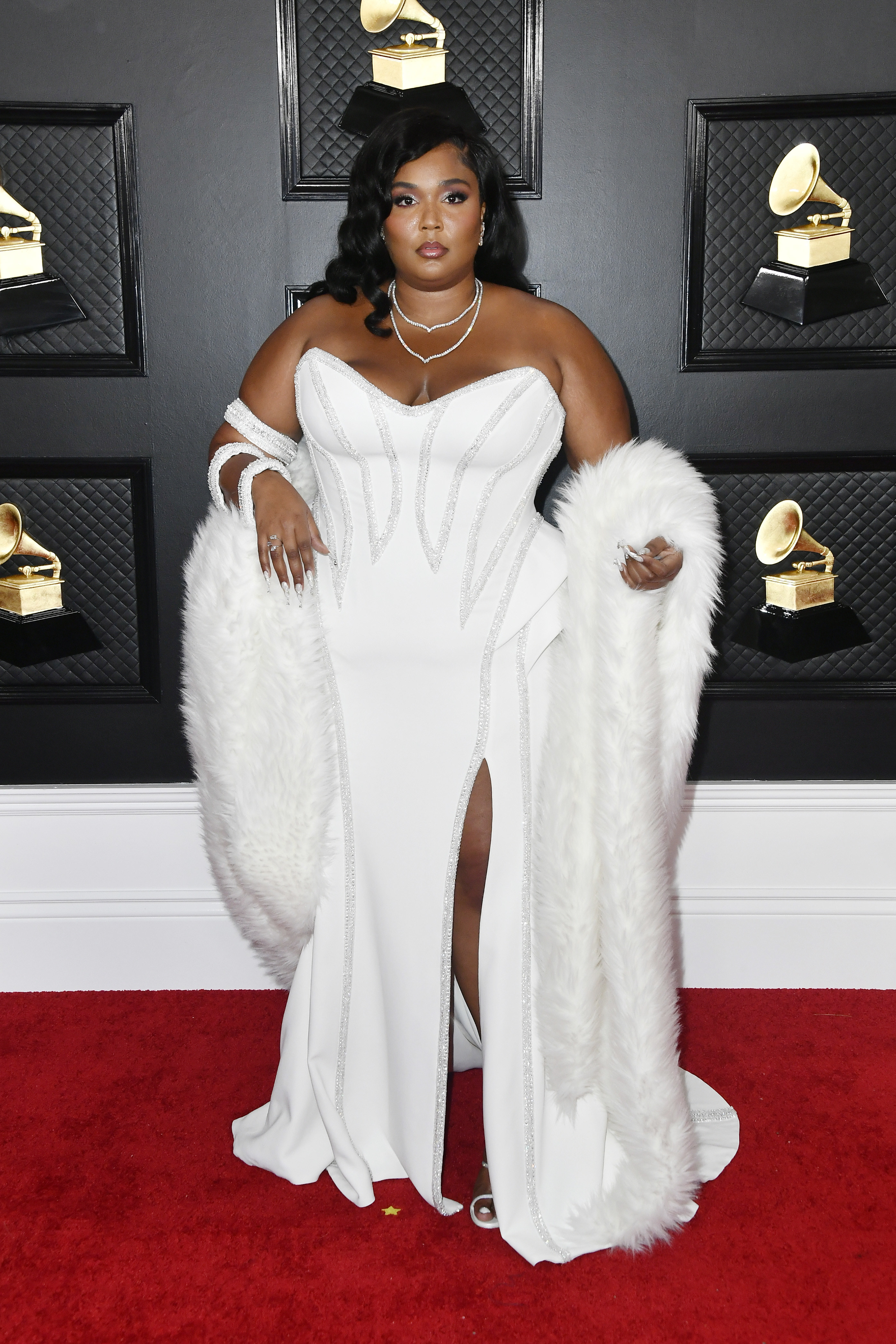 Lizzo wearing a strapless gown with a stole on the Grammy Awards