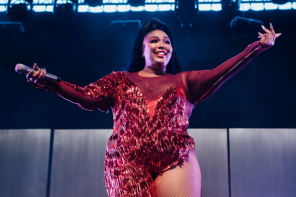 Lizzo performing on stage and smiling