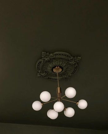 reviewer image of medallion installed and painted dark green to match the rest of ceiling