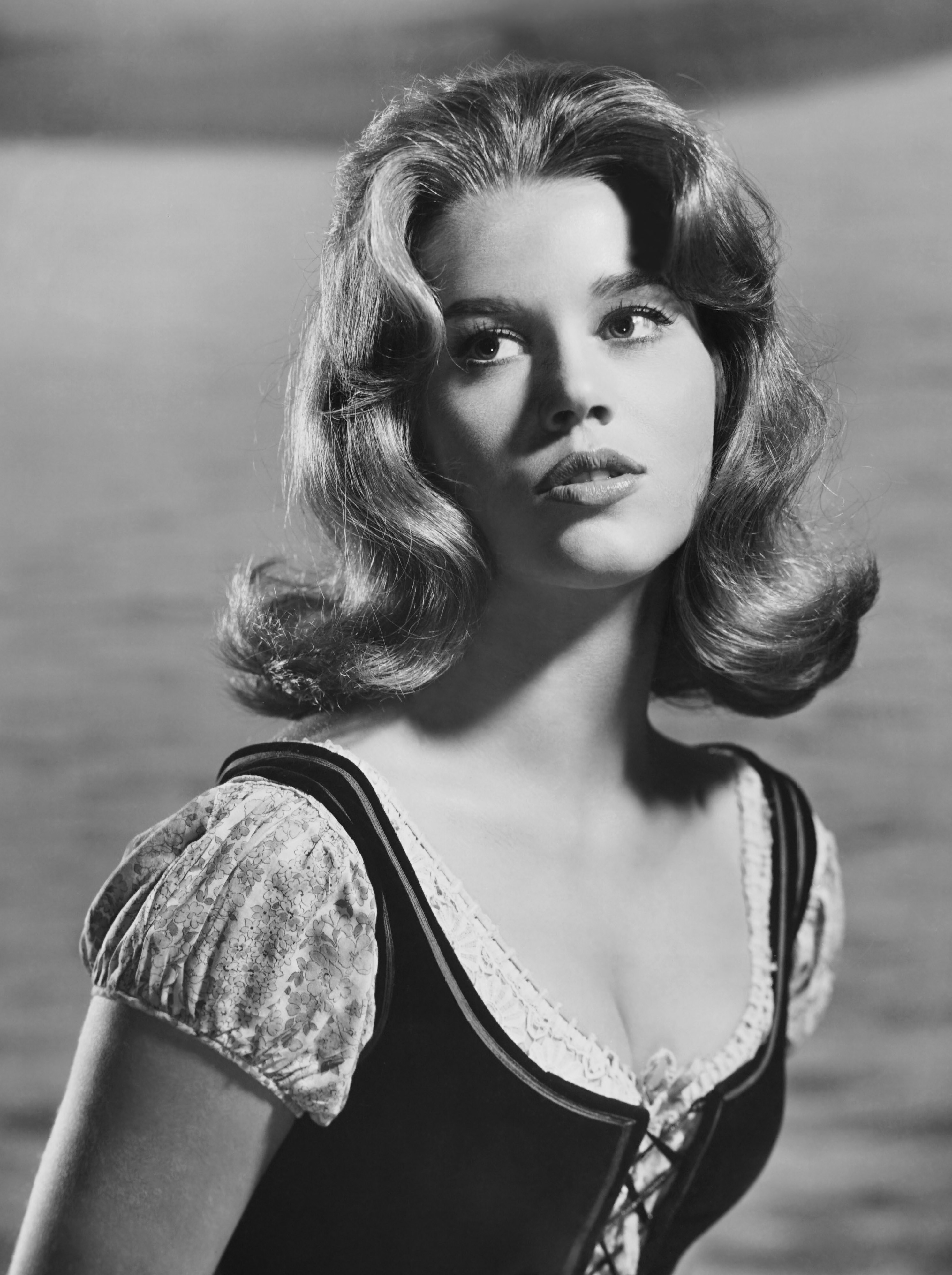 Jane Fonda wearing a prairie-like dress in front of a body of water