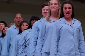 The New Directions Glee Club wear matching pajamas while standing on a mattress