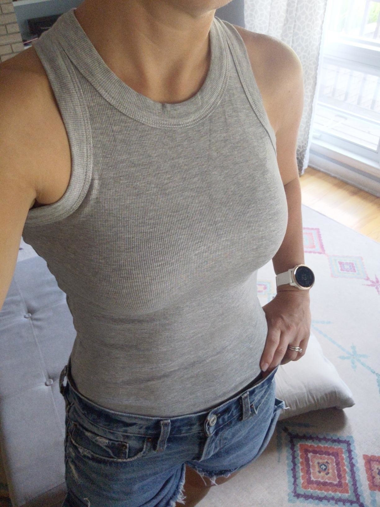 image of reviewer wearing the heather gray tank with denim shorts