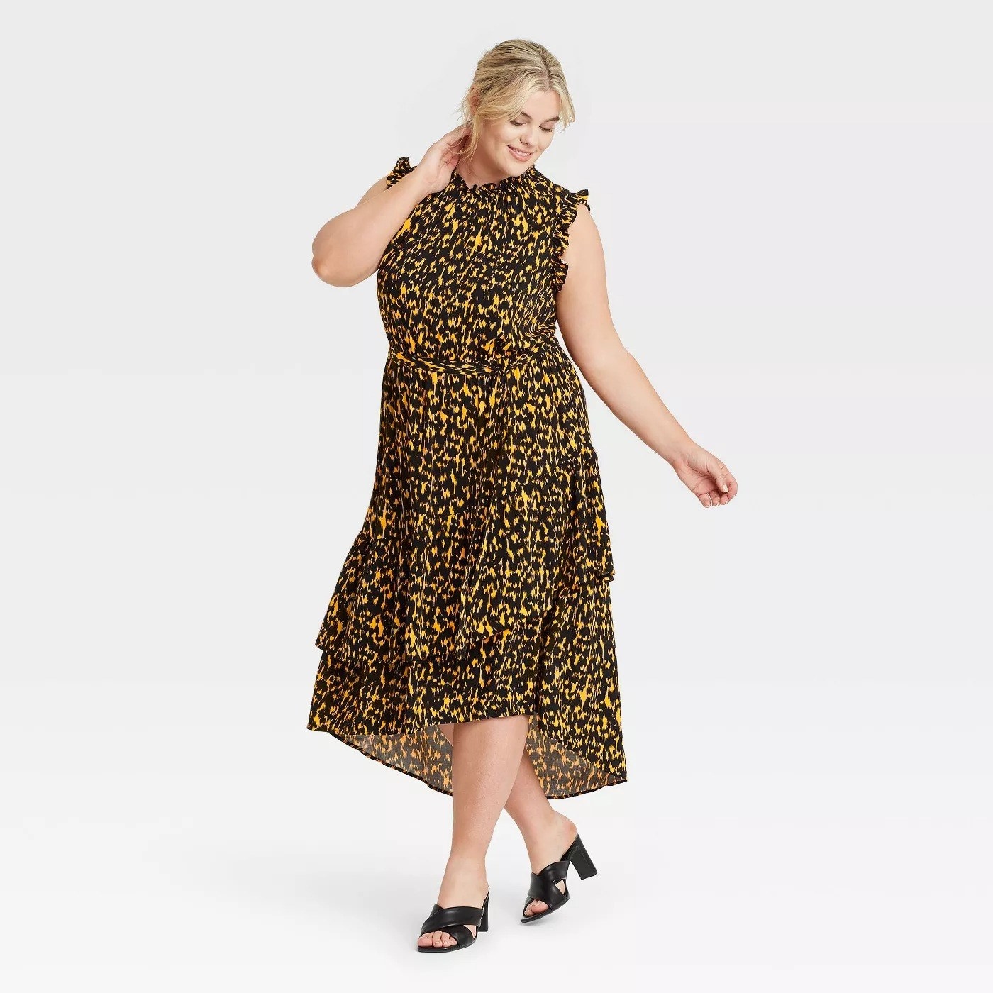 Model wearing black and yellow patterned dress, goes past the knee
