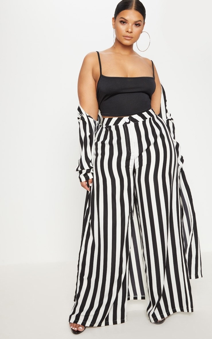Model wearing wide-legged black and white striped pants with black top