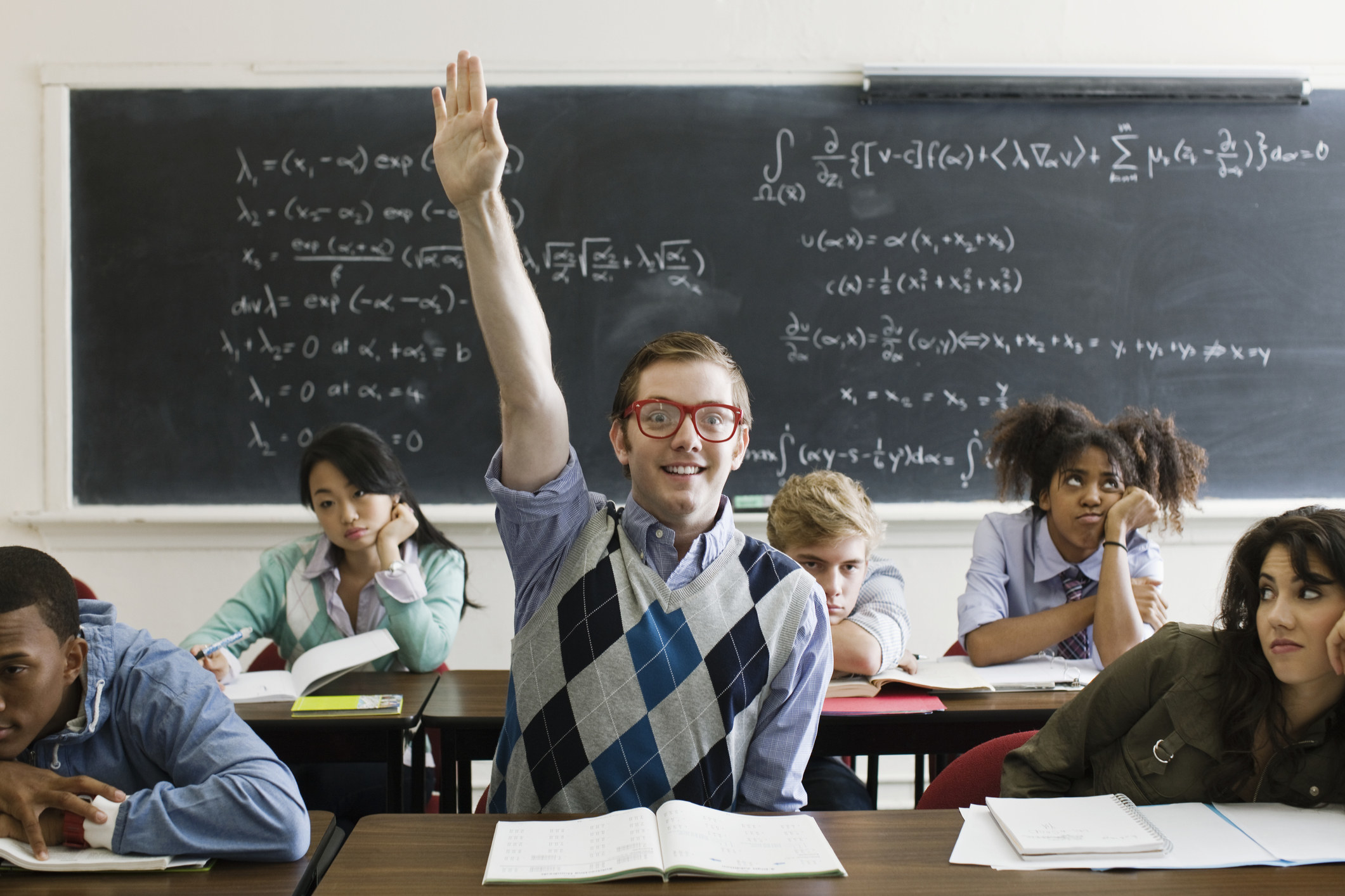 man raising his hand eagerly in class