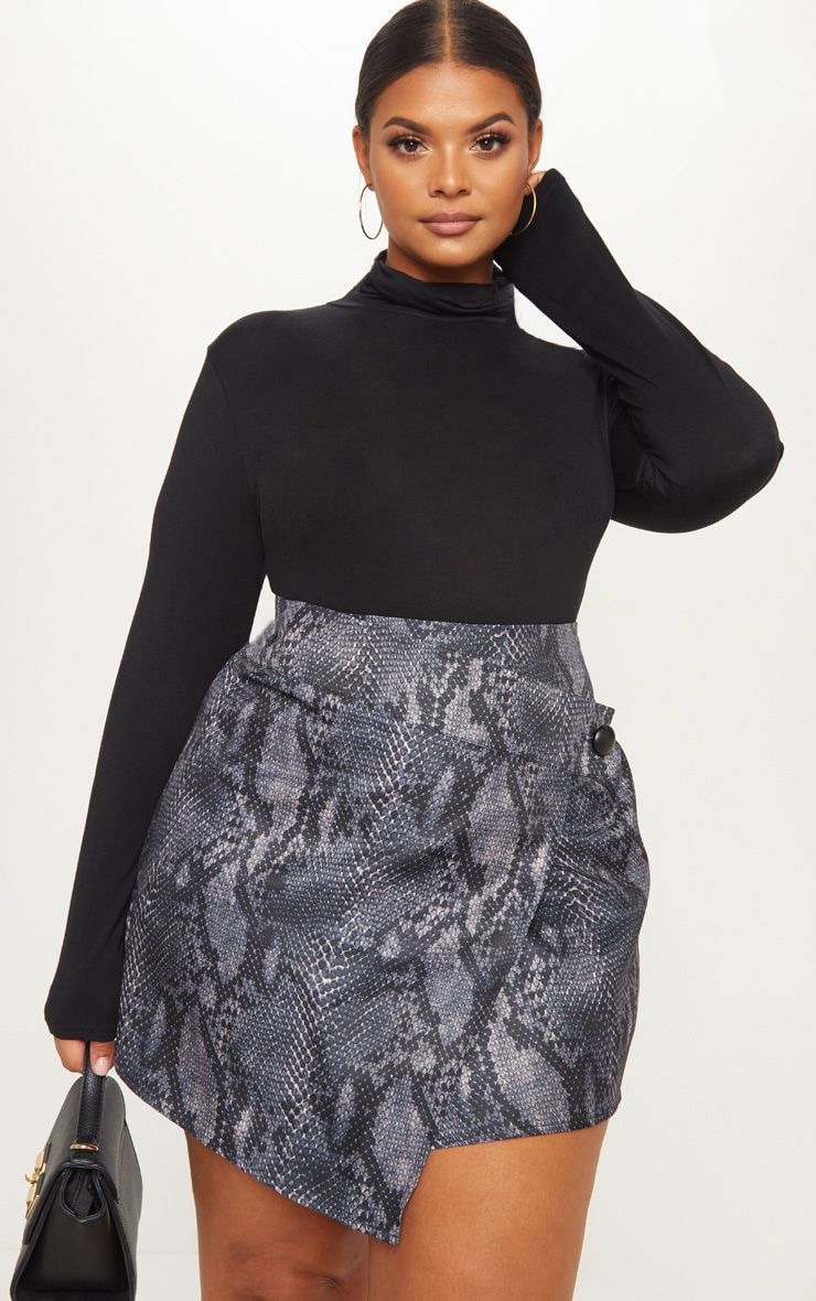 Model wearing grey snakeskin skirt with black turtleneck