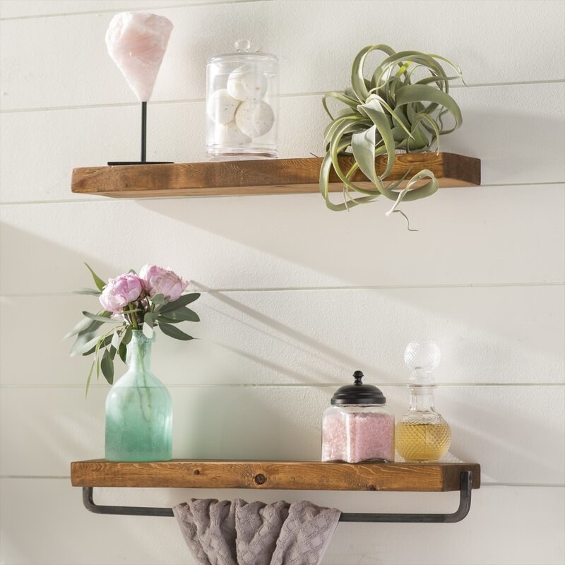 two wood floating shelves with product on top