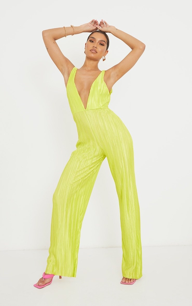 Model wearing a green jumpsuit with pink shoes