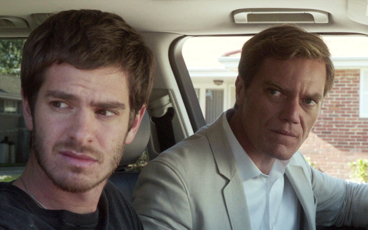 Andrew Garfield and Michael Shannon sitting in a car and looking out the side window