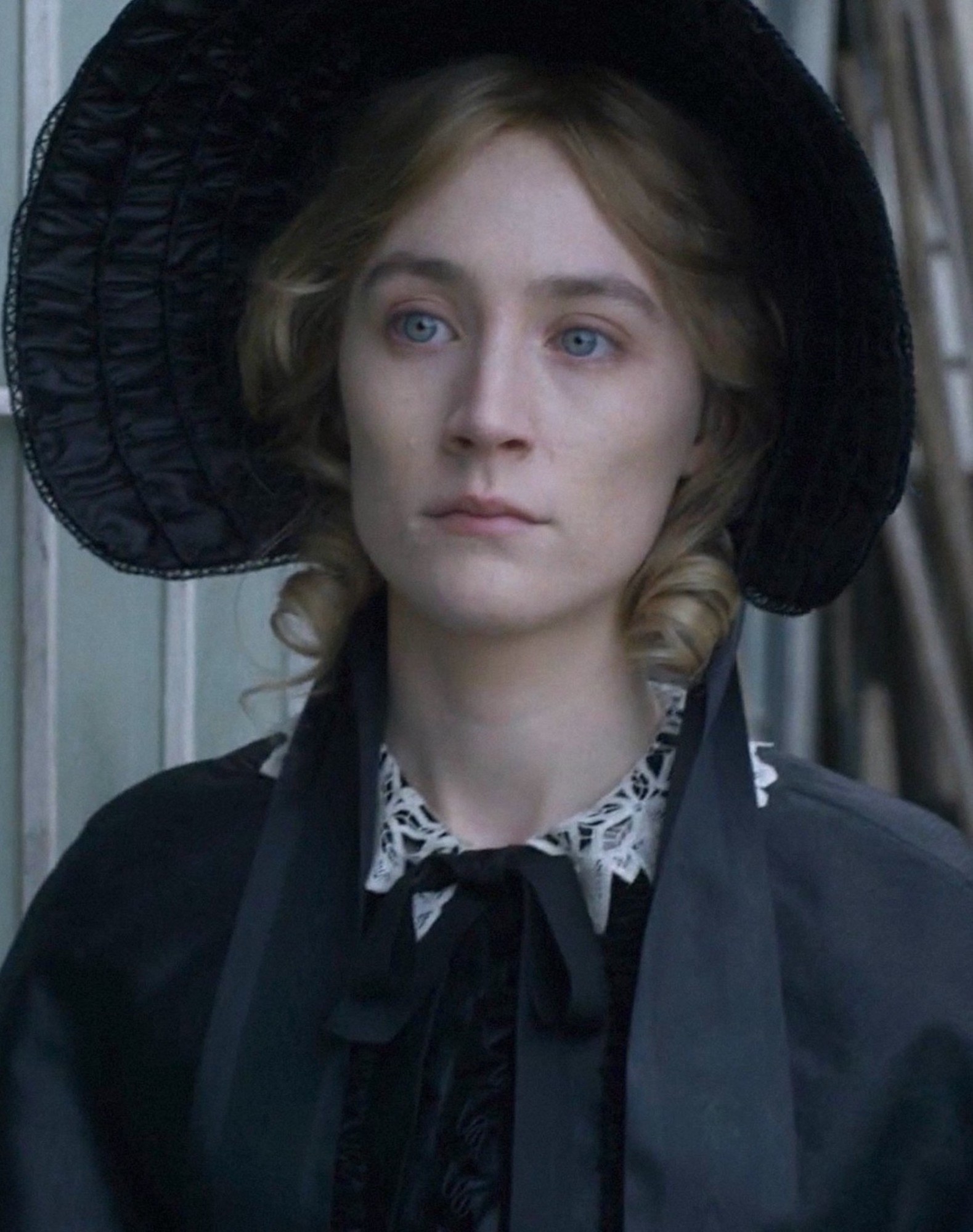 Saoirse Ronan wearing a wide brimmed hat, looking gloomy