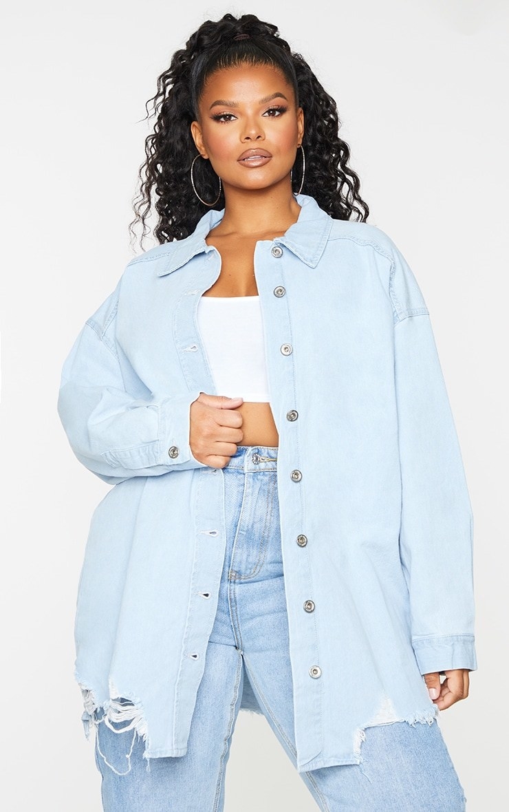 Model wearing oversized light wash denim top over white tee with jeans