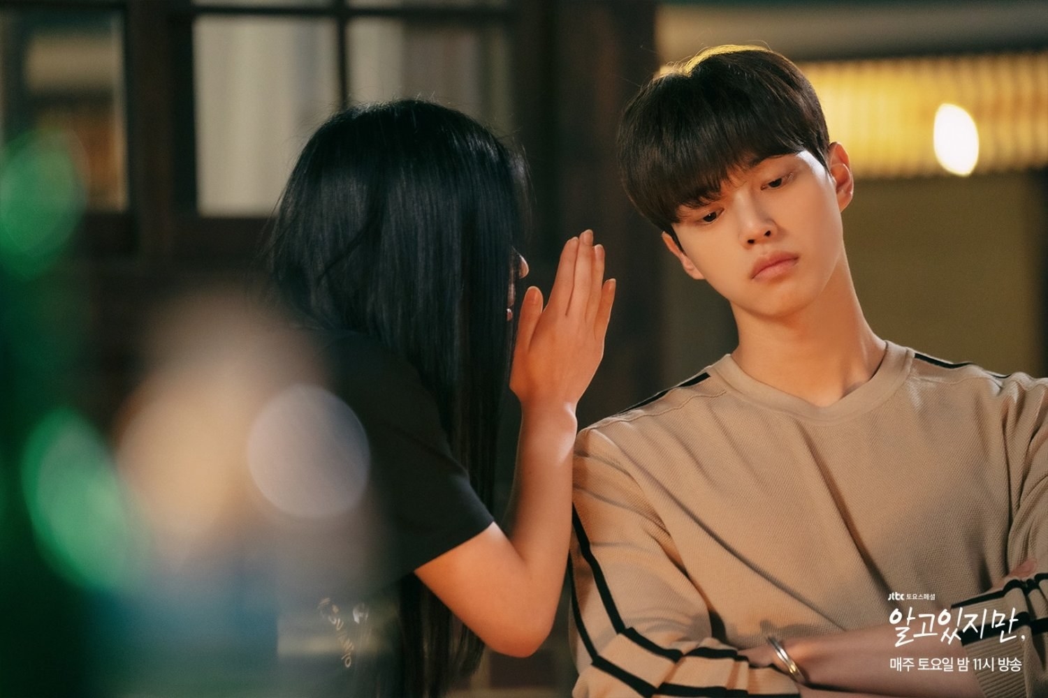 Do-hyeok&#x27;s cousin has hand up, whispering to Jae-eon as he looks away and leans toward her
