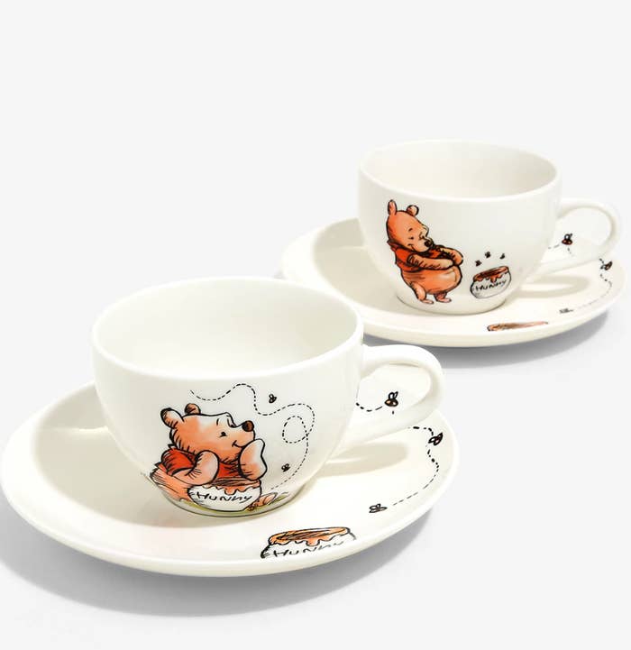 two winnie the pooh themed tea cups and saucers