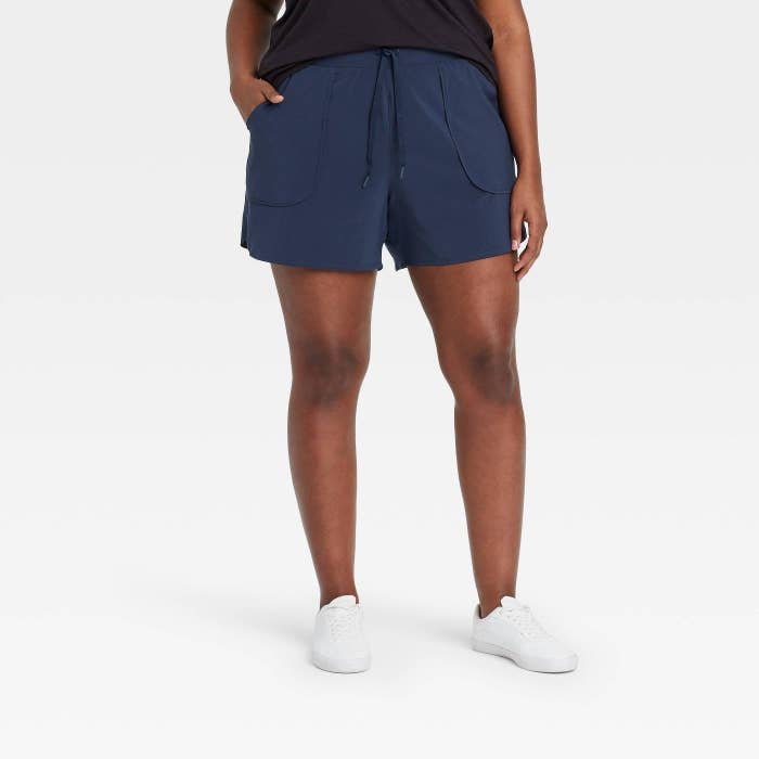 model wearing the woven shorts with pockets in the front in navy