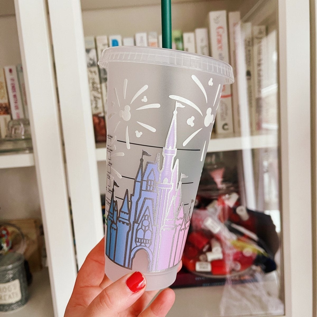 a clear cup with cinderella castle on it in pink and blue ombre