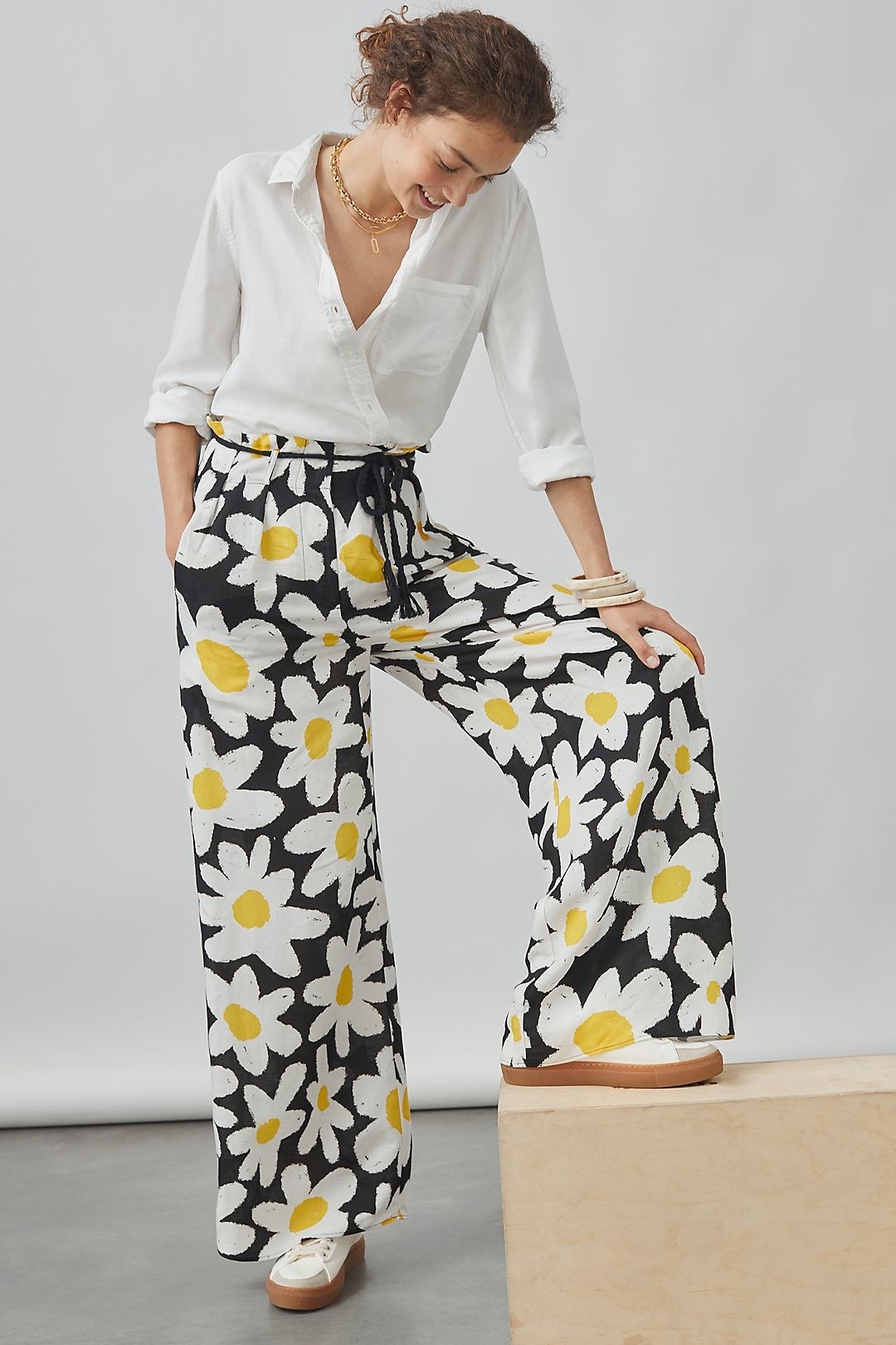 a model in the blue, white, and yellow daisy pants