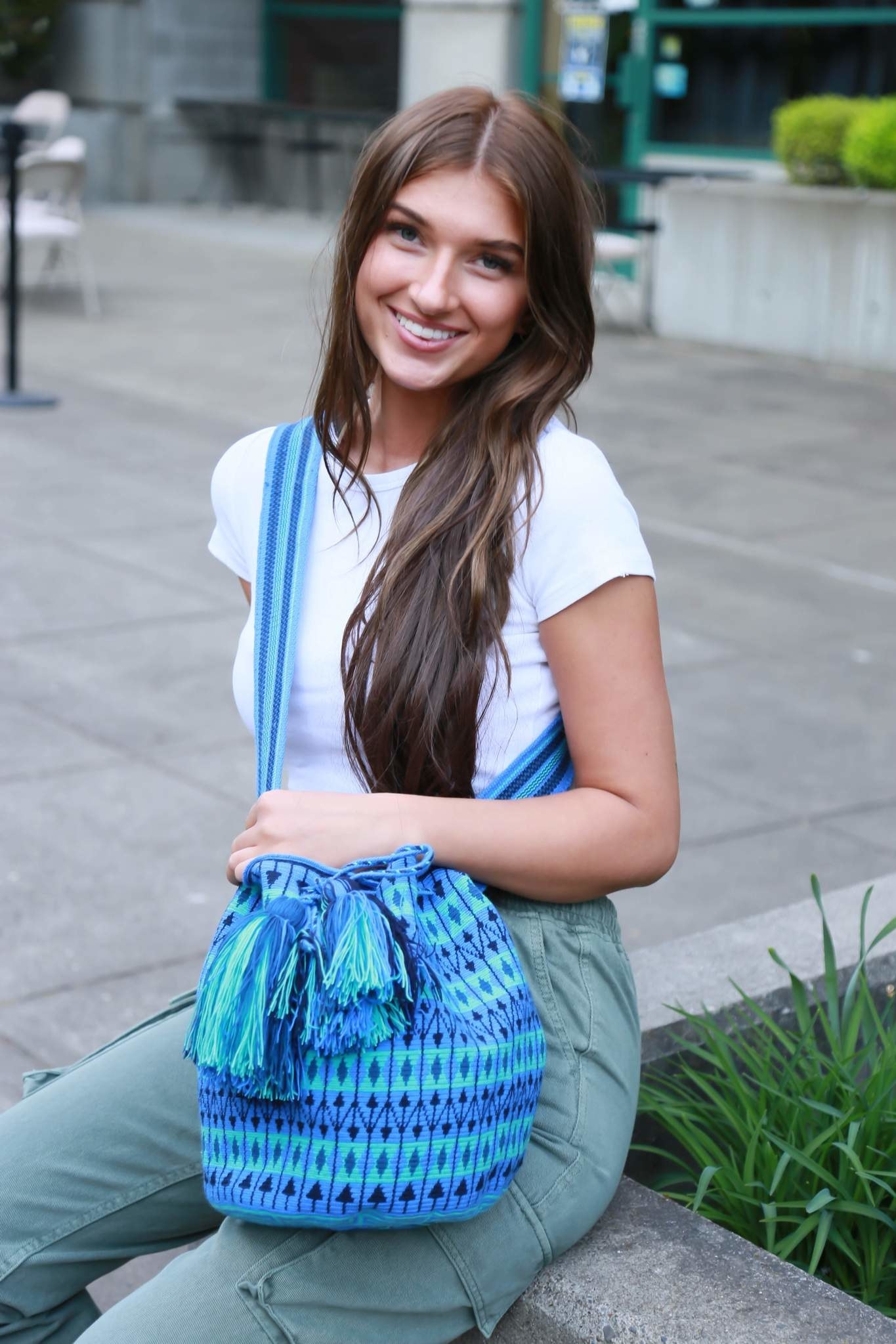 a model holding the blue woven bag