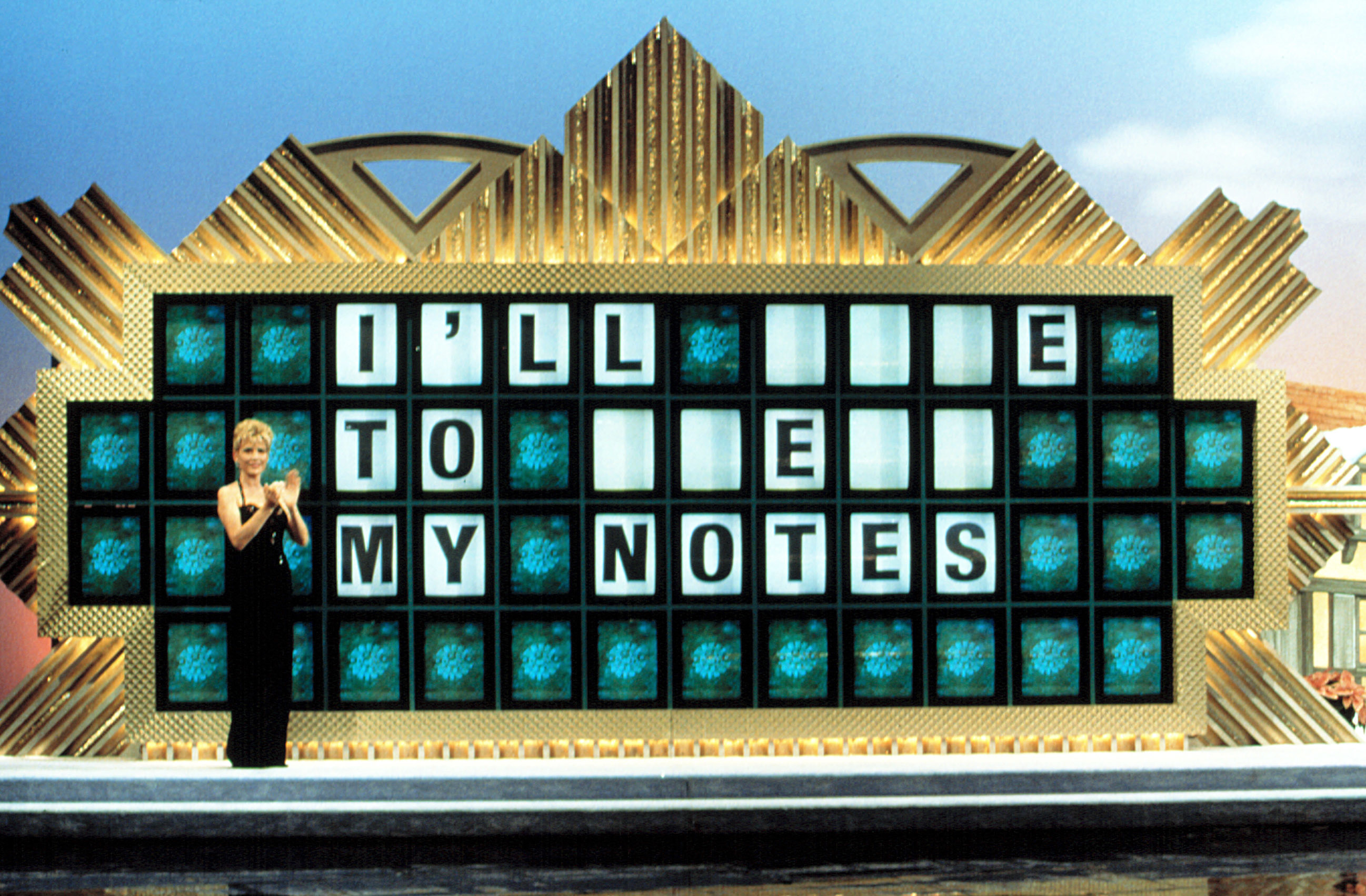 Vanna White stands in front of a puzzle