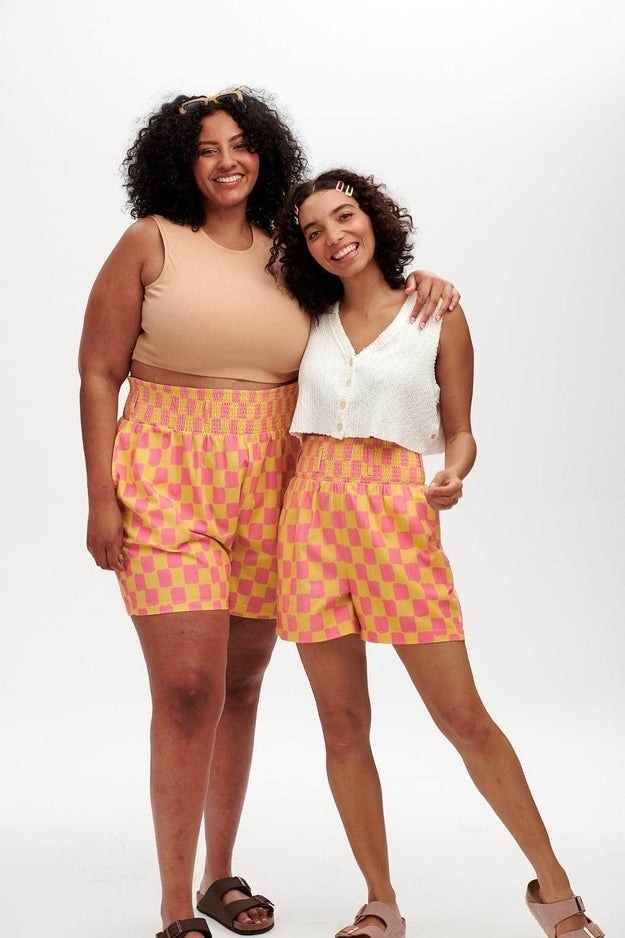 two model wearing the pink and yellow shorts which have an elastic waistband