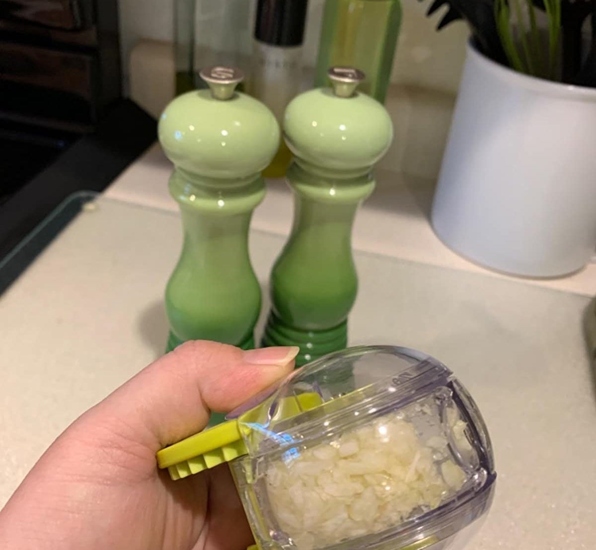 reviewer holding chopper filled with chopped garlic