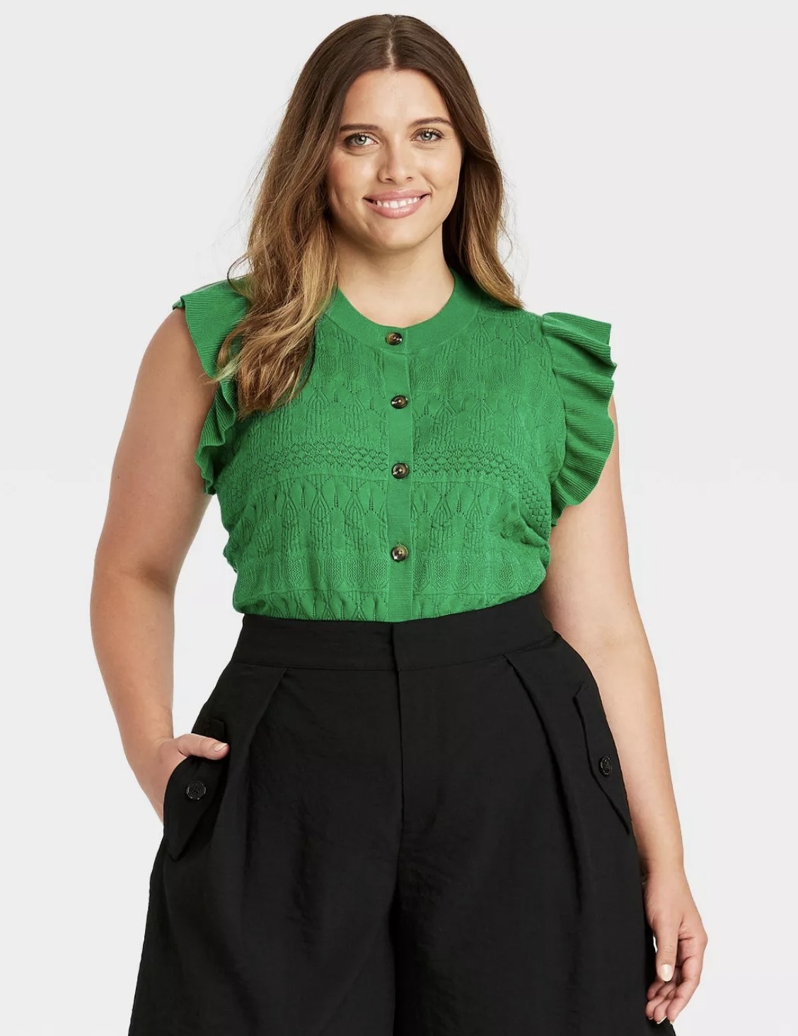 model wearing the sweater vest with ruffled sleeves in green