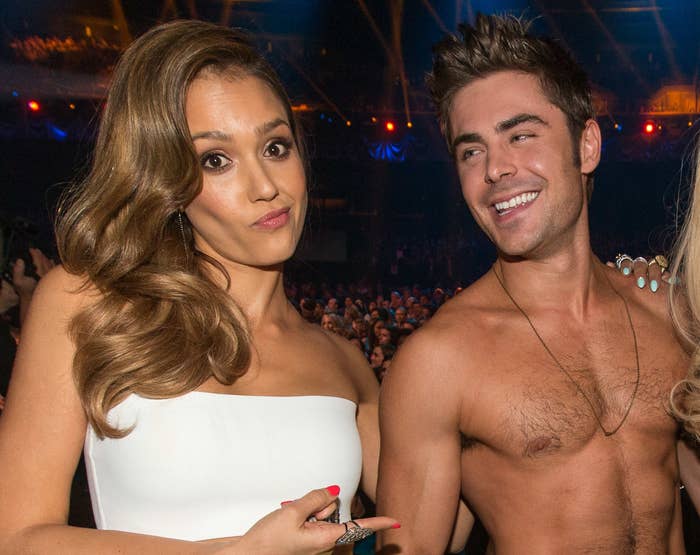 Jessica points to a shirtless Zac and smiles during an old awards show