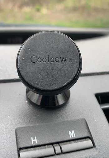 a reviewer photo of the small mount installed on their car dash
