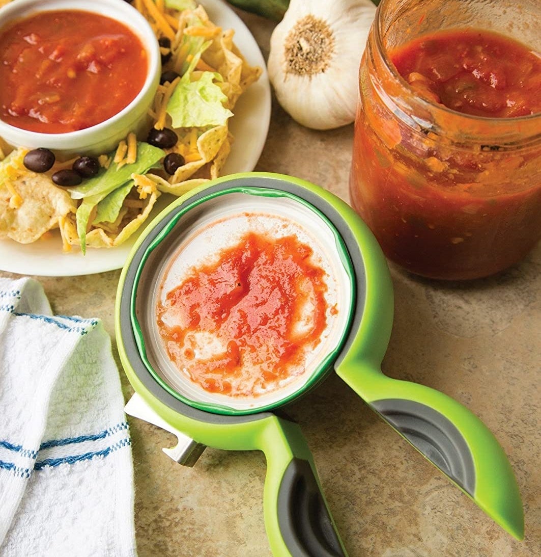 The jar opener around a lid of salsa