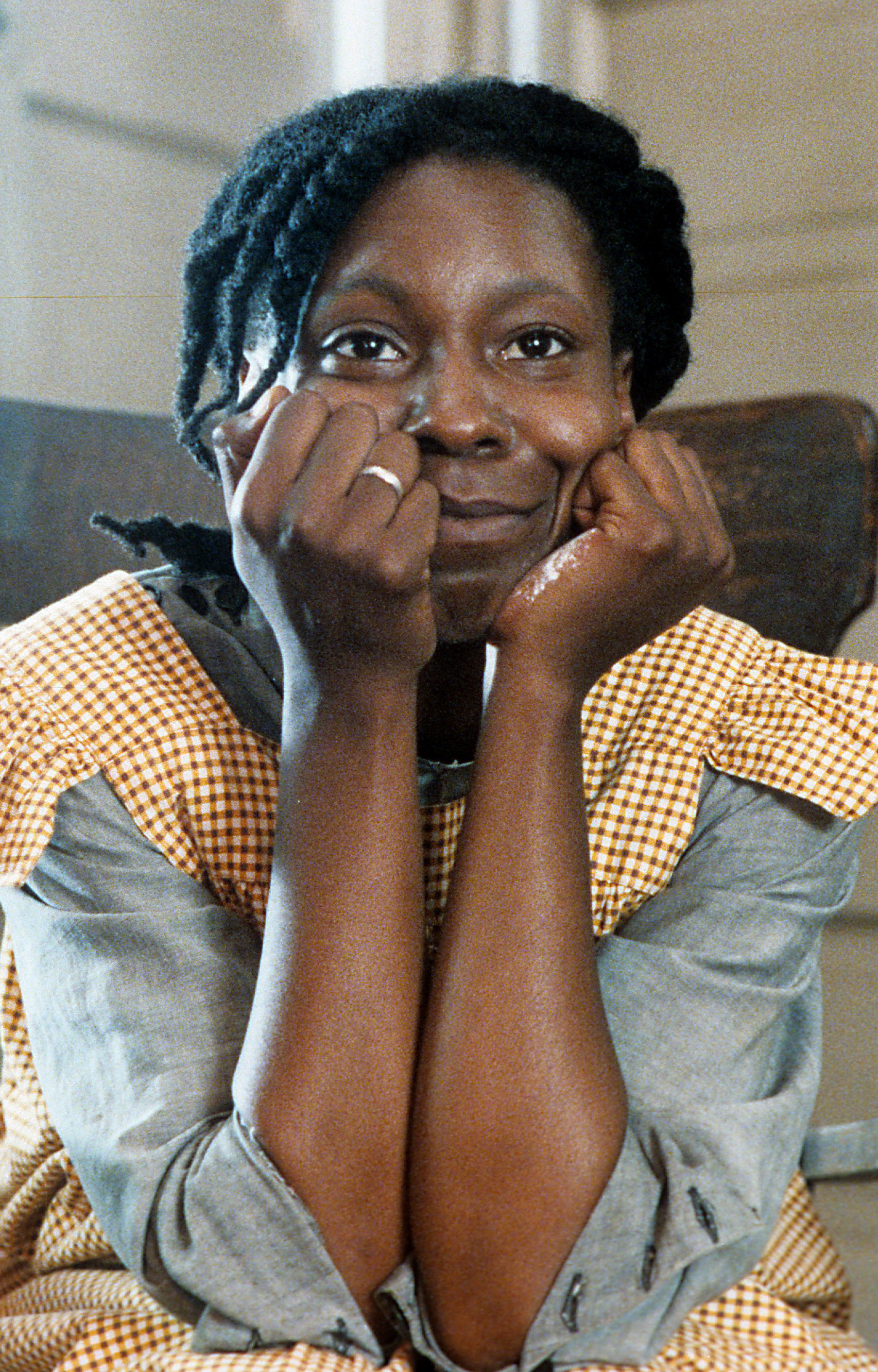 Whoopi Goldberg sitting in a chair, resting her head in her hands