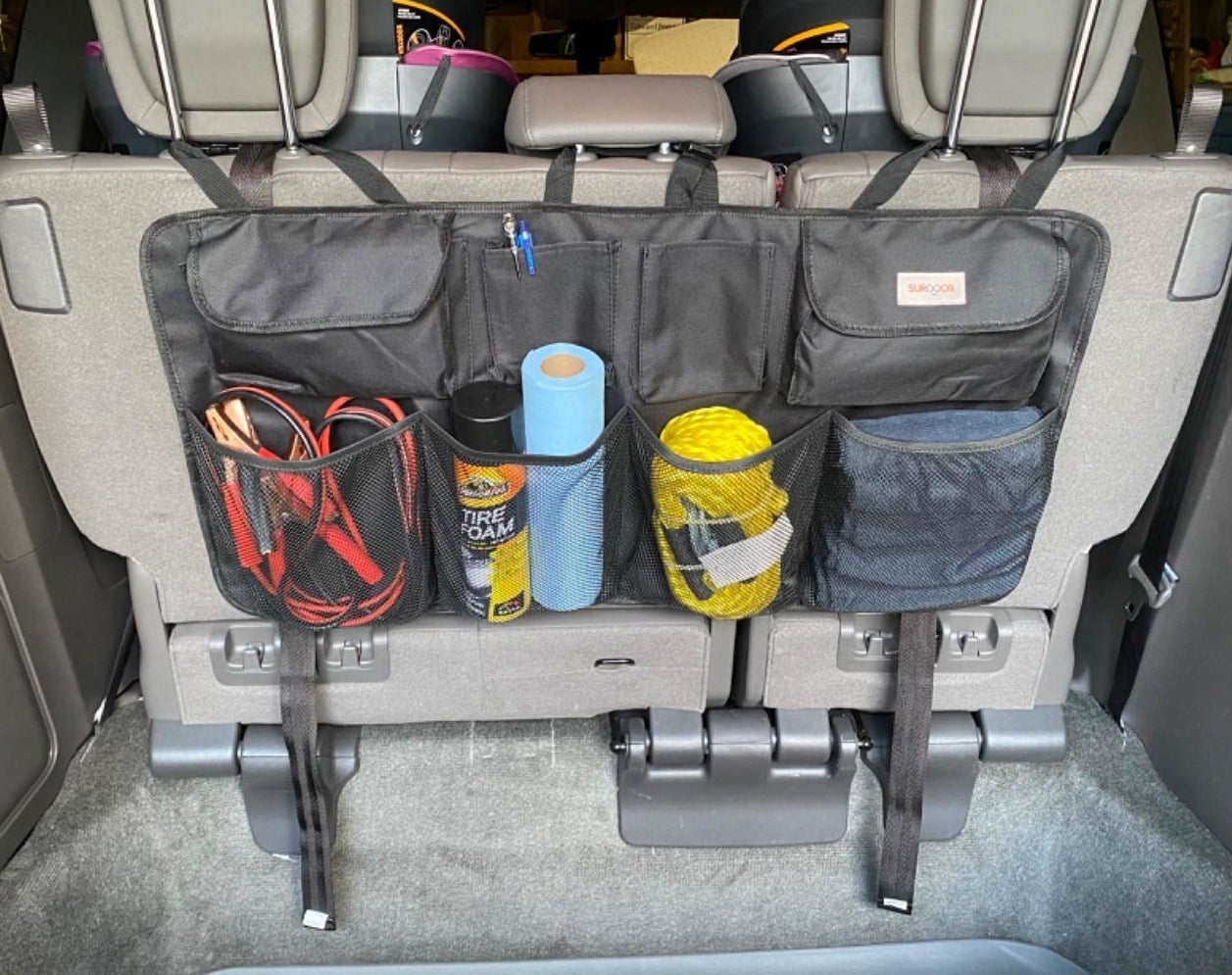 a reviewer photo of the black organizer in their trunk filled with supplies