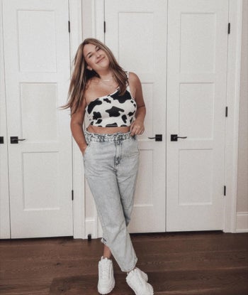buzzfeed writer ali wearing cow print top with jeans and sneakers