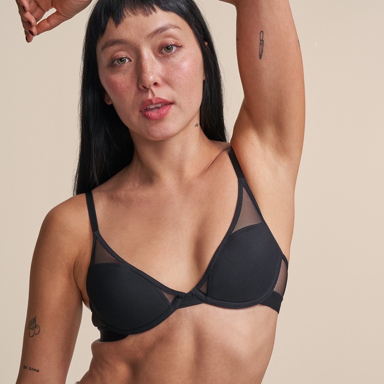 model wearing the black bra with mesh panels in it