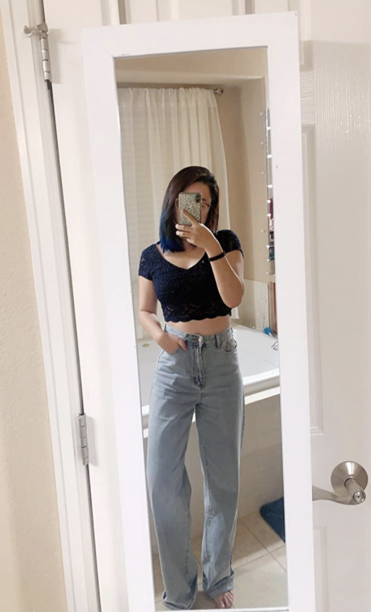 reviewer taking a mirror selfie wearing jeans with black crop top