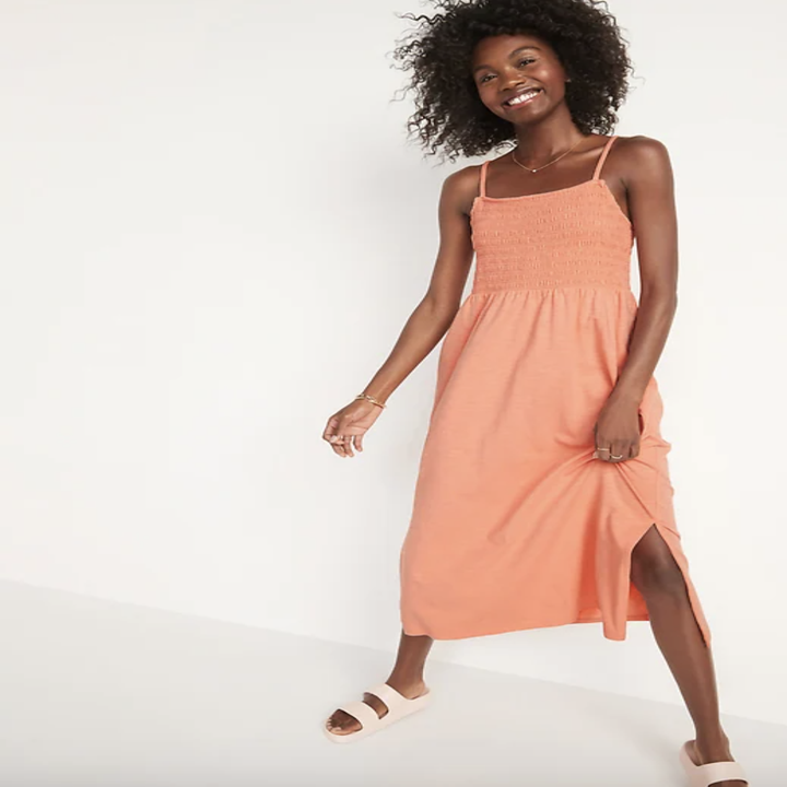 Model in an orange smocked maxi dress with tank straps