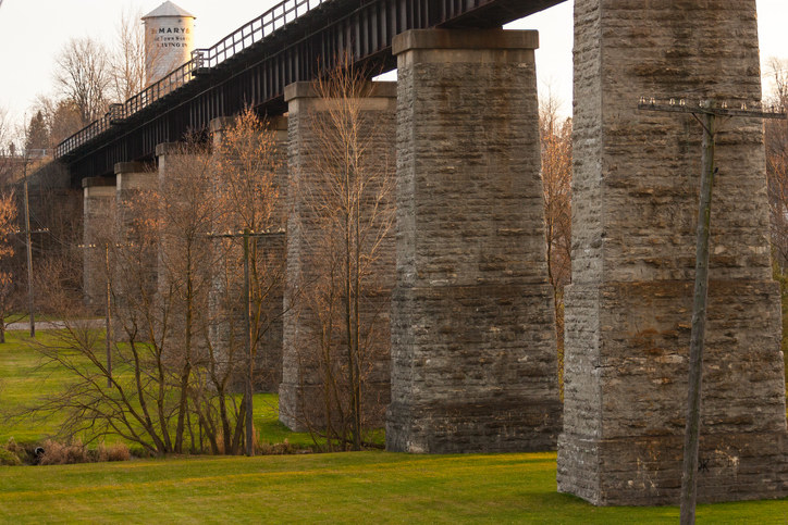 Trestle Bridge in St. Mary&#x27;s, with view of an old tower in the back which reads &quot;St. Mary&#x27;s, The Town Worth Living In&quot;.