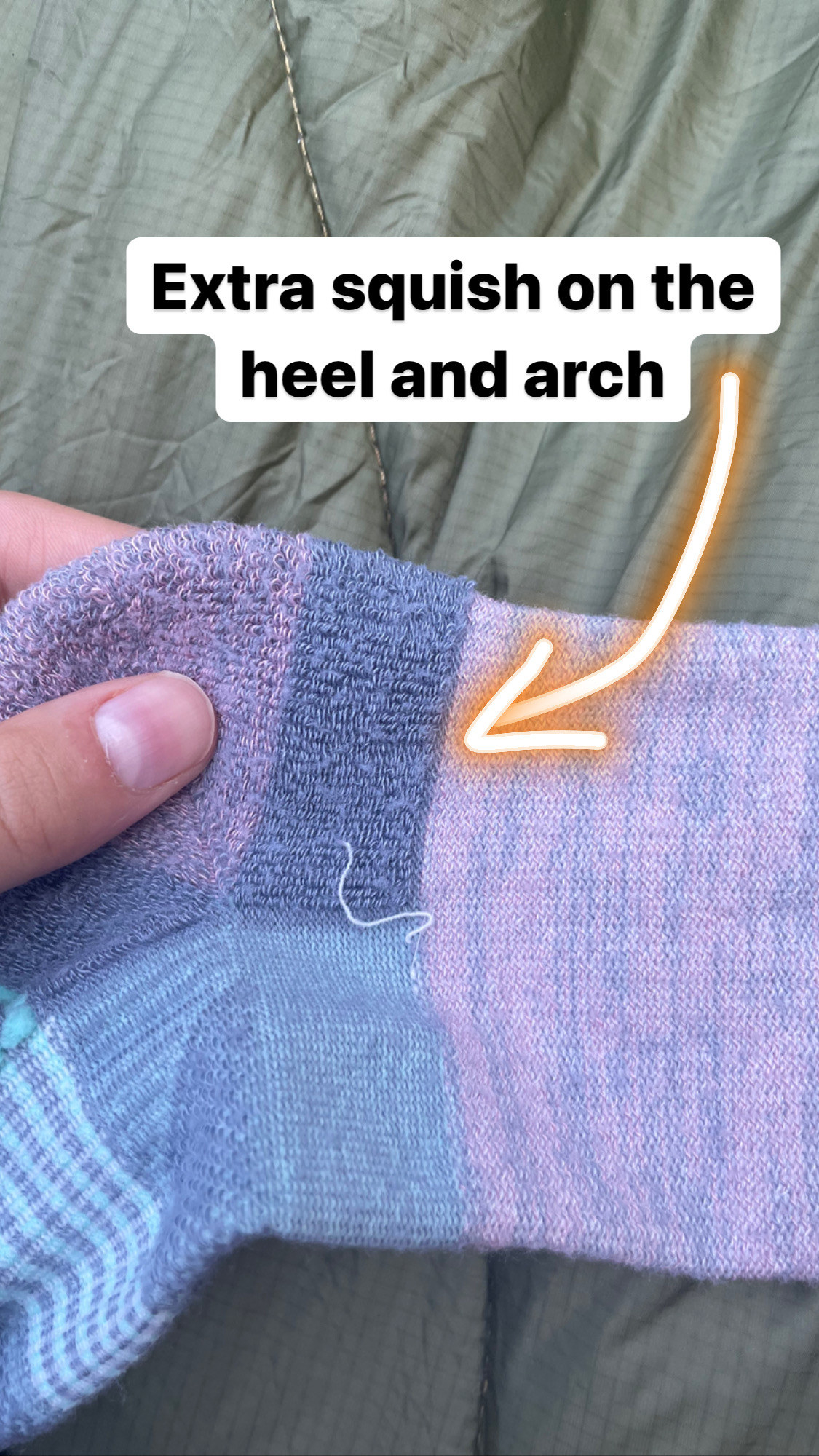 the midweight socks inside out captioned &quot;extra squish in the hell and arch&quot; with an arrow pointing to extra fabric in those areas