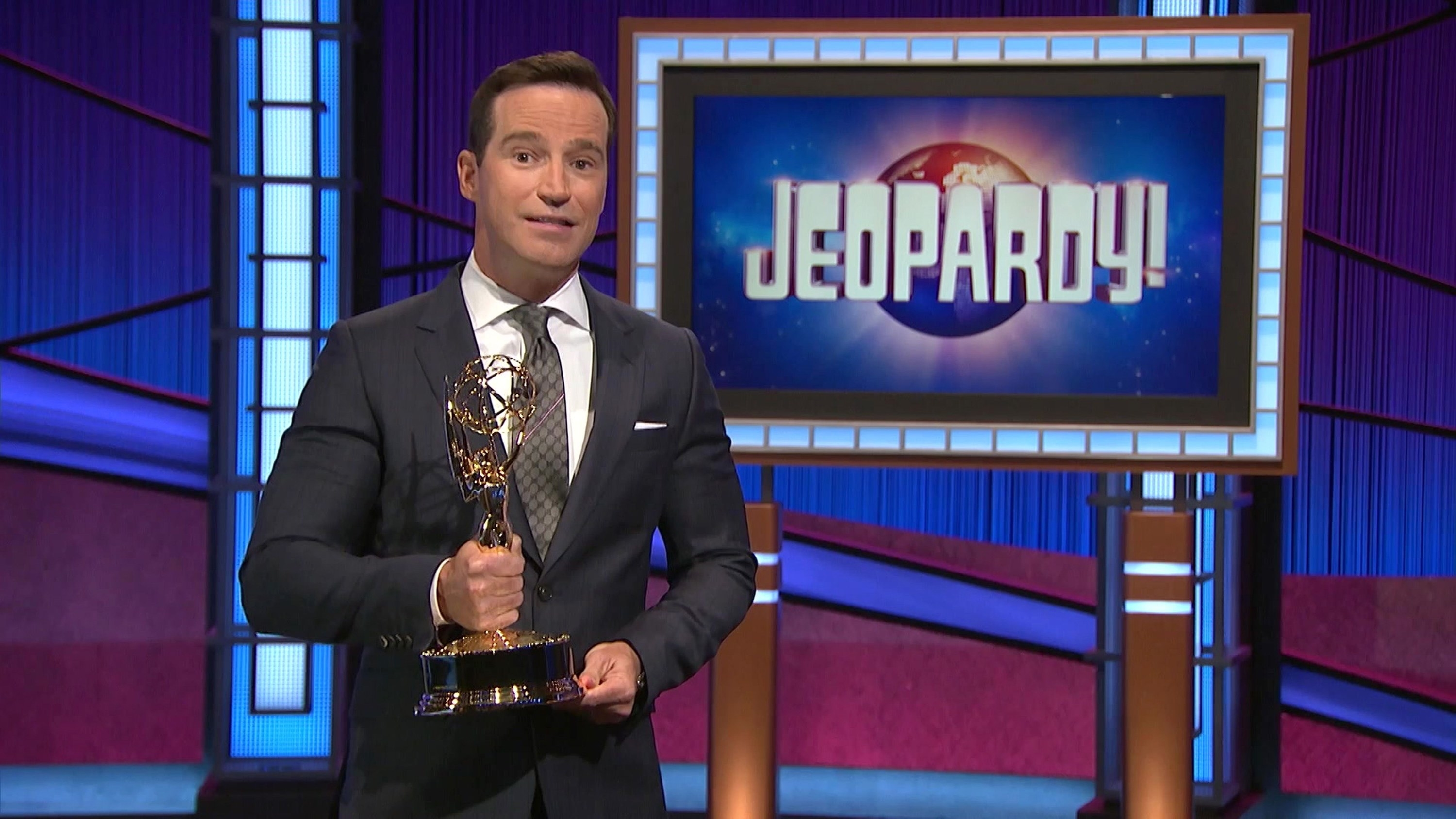 Photo of Mike Richards on the Jeopardy! set holding a daytime Emmy