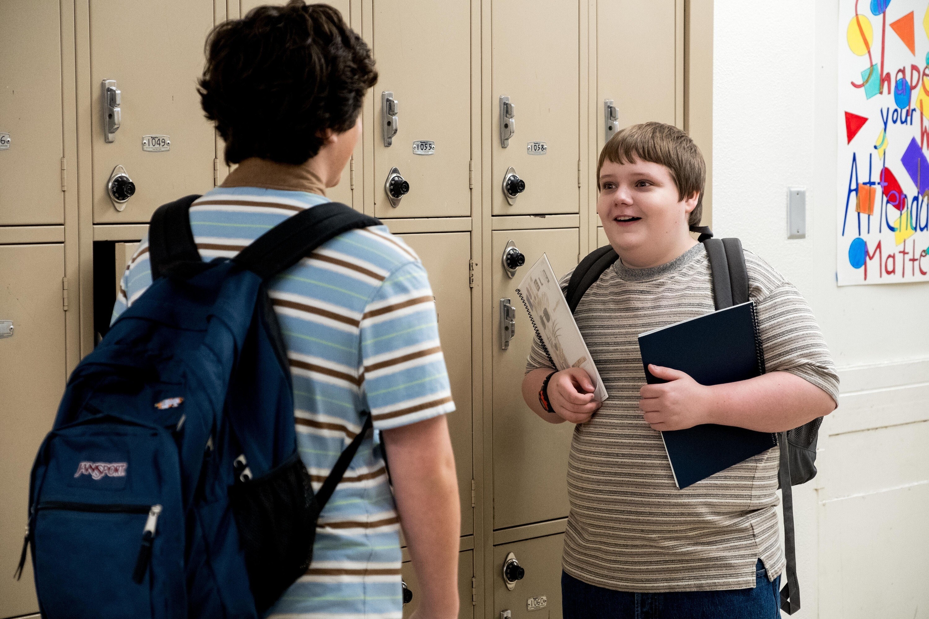 Taj Cross and Dylan Gage talk to each other next to their lockers