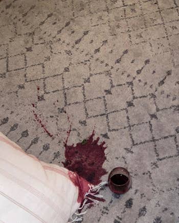 reviewer photo showing a rug with a big red wine spill on it