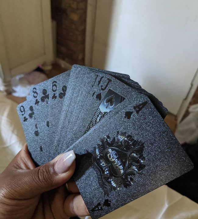 image of reviewer holding the Joyoldelf cards fanned out in their hand