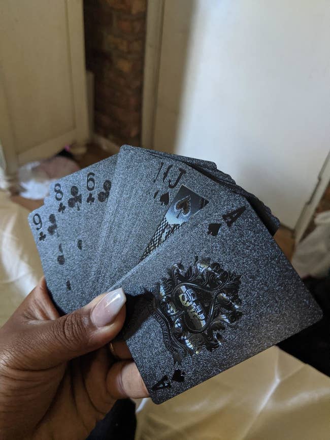 A reviewer holding the cards fanned out in their hand