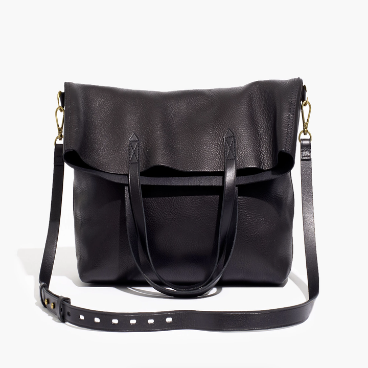 leather purse with thin strap and handles flopped to one side. it has gold buckle details on the crossbody strap.