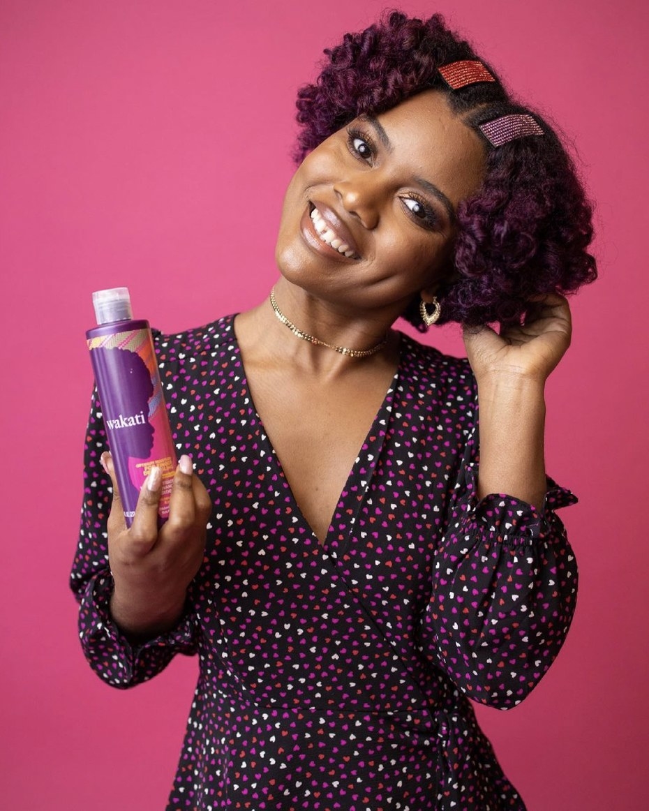 A woman holding a bottle of detangling conditioner