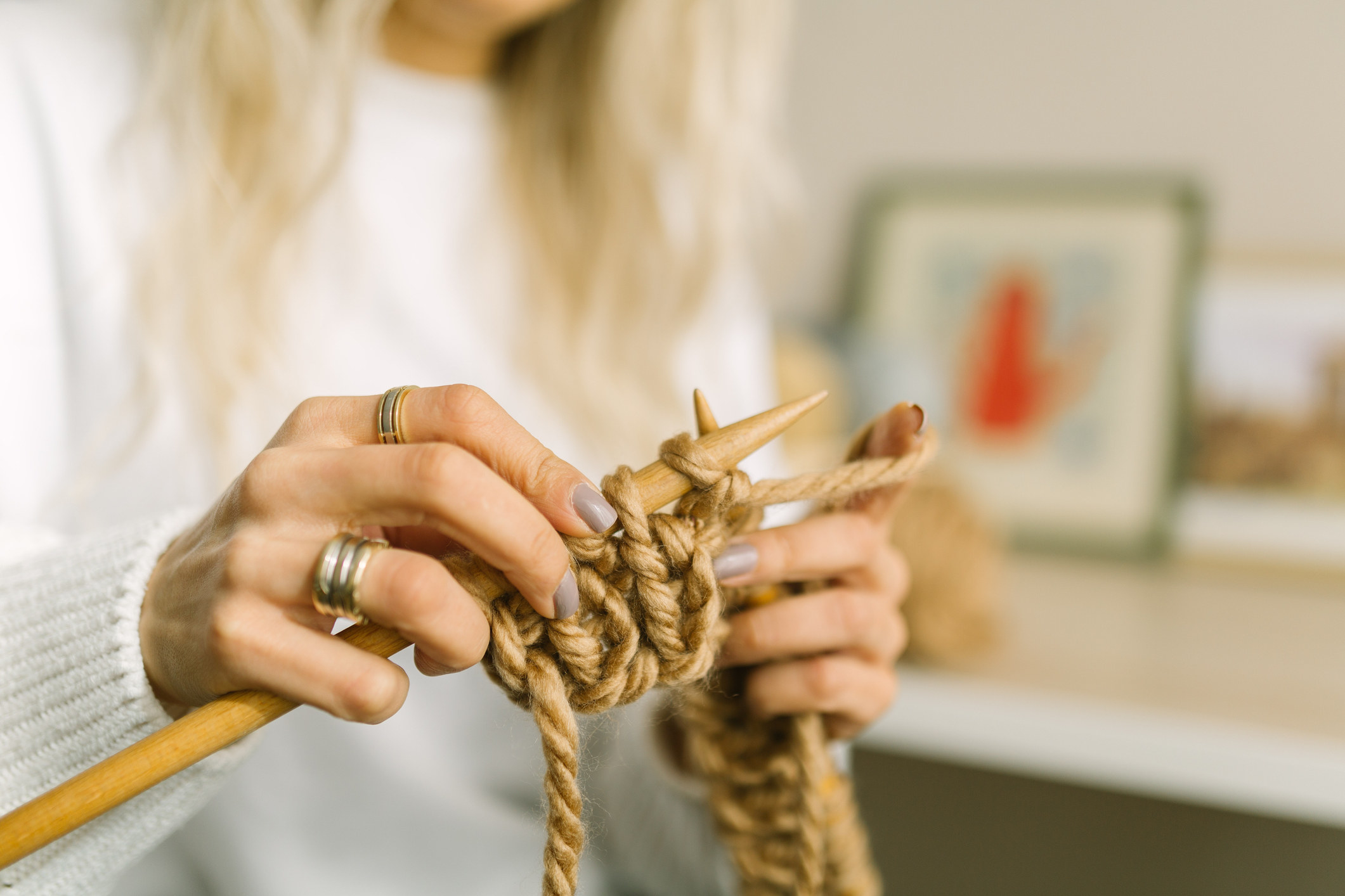 A woman knits with thick yarn.