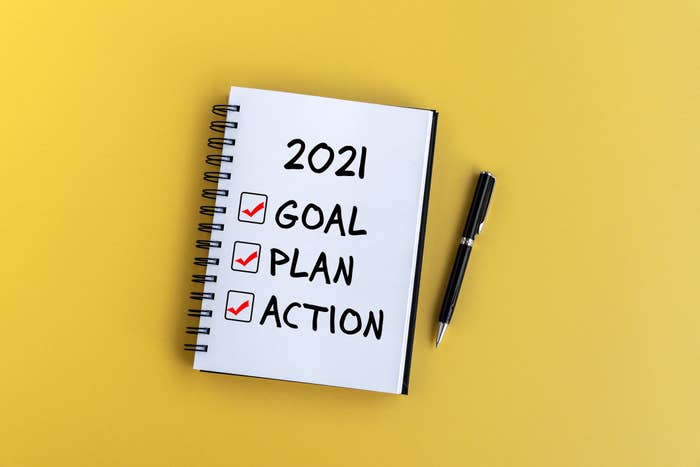 A notepad with a list on labeled "2021" with "Goal Plan Action" checked off