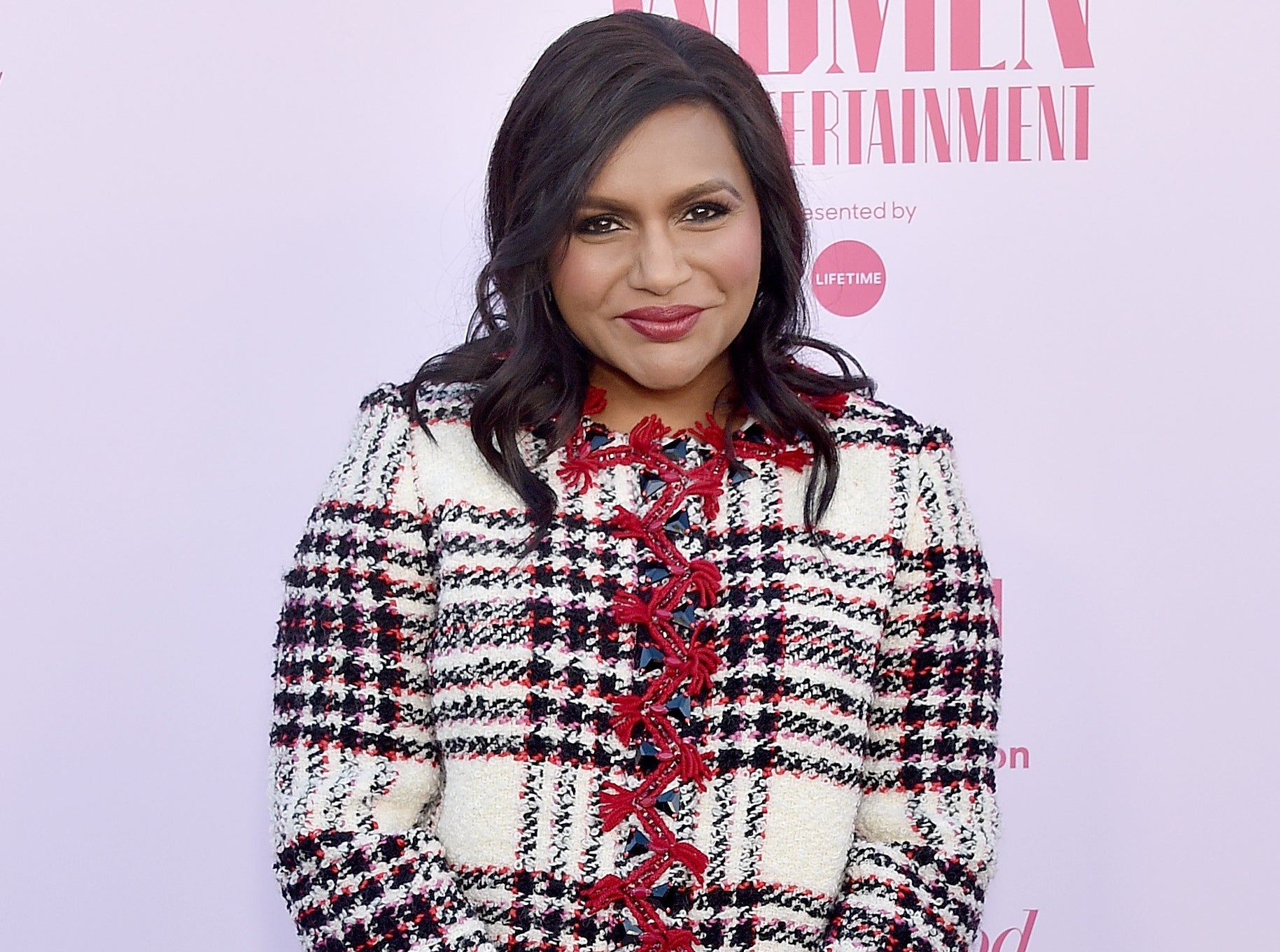 Mindy wears a white black and red tweed jacket