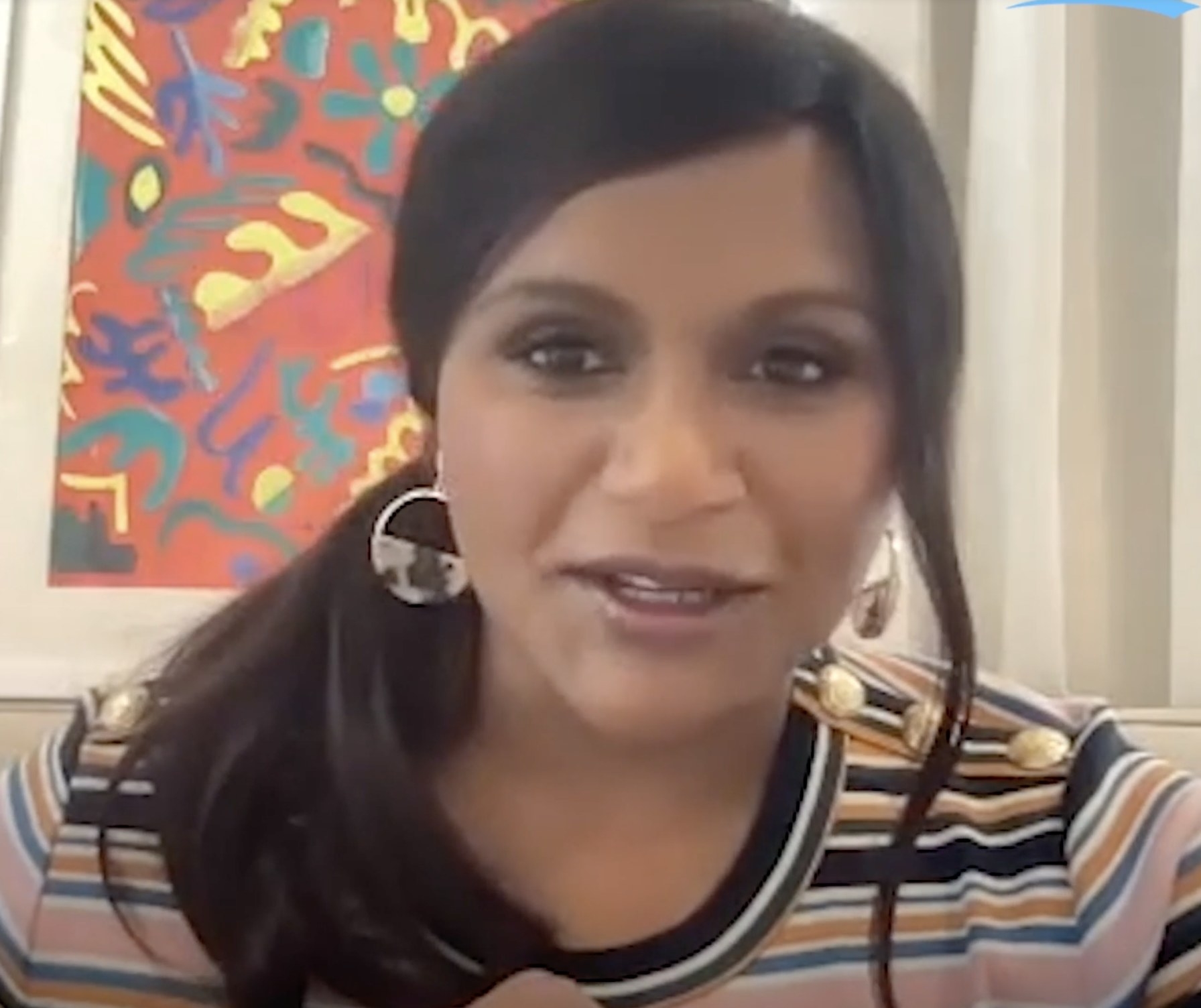 Mindy chats during her interview while wearing a striped shirt